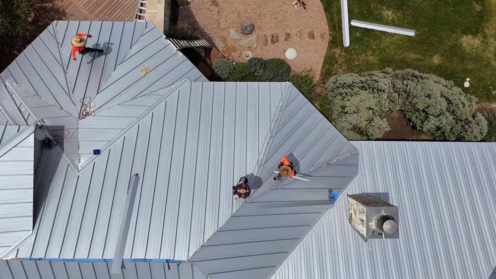 Wide angle of a standing-seam metal roof installation showing clean panel seams